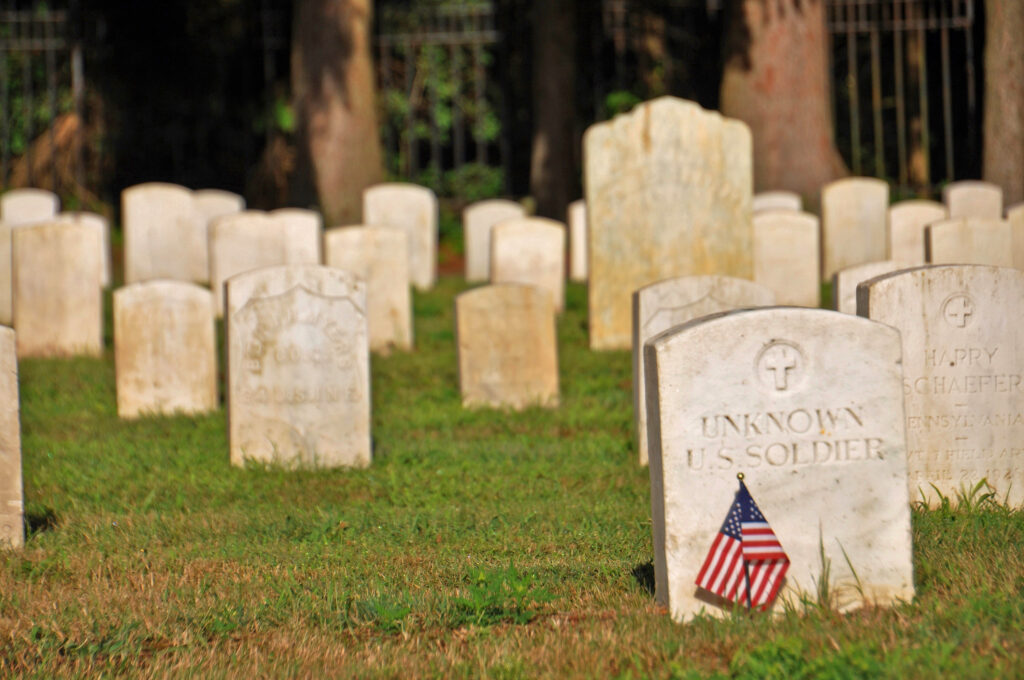 Color photo of the Sackets Harbor Military Cemetery graves and stones with an unknown U.S. Soldier's grave in the foreground